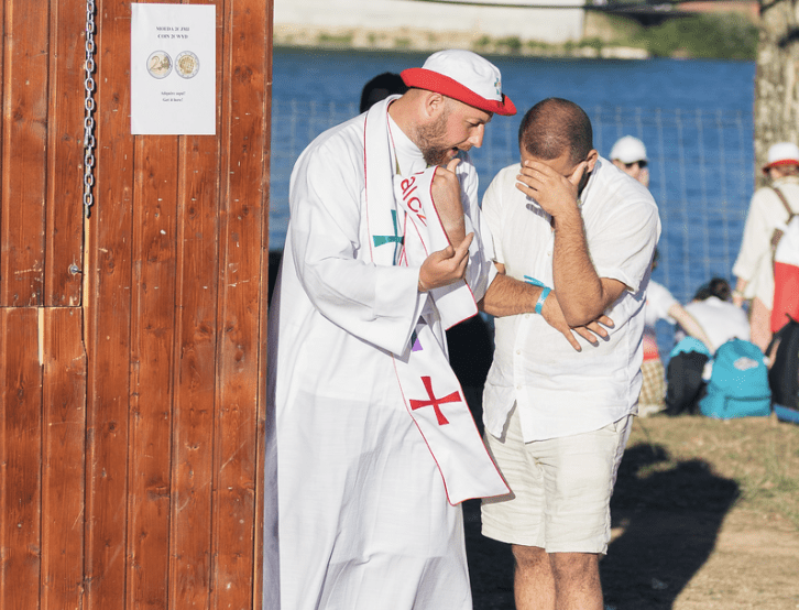 A priest administers the Catholic sacrament of confession to a man during a FOCUS mission trip.